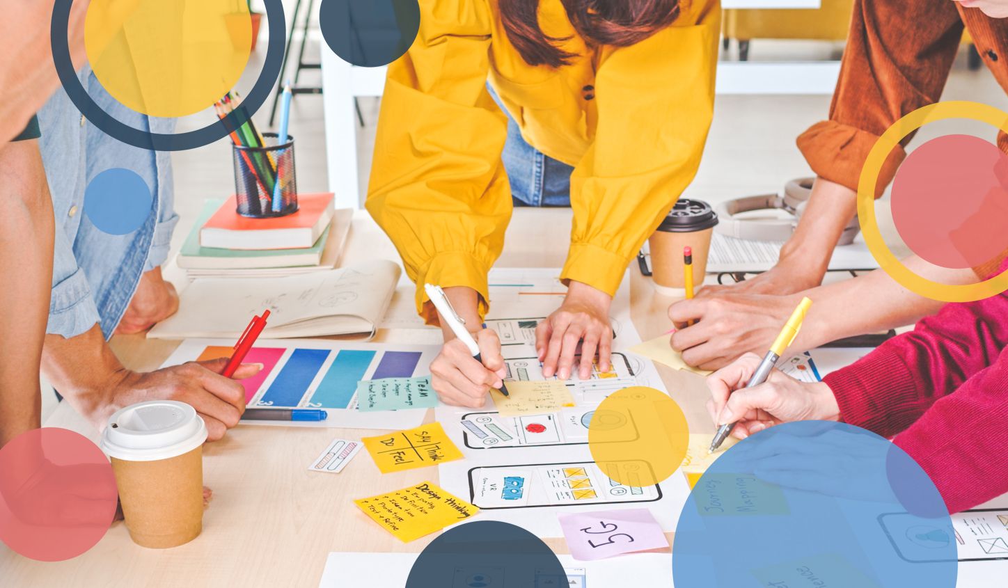 five people working together on a project using sticky notes on a table